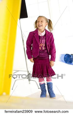 Young girl laughing wearing a burgundy skirt outfitand blue boots in front of a white back drop. View Large Photo Image Stock Photo - Young girl laughing wearing a burgundy skirt outfitand blue boots in front of a white back drop. . Fotosearch