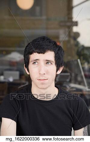 A skinny young man sits in front of a shop while enjoying a drink. September 1, 2006 credit - RD / Retna Digital View Large Photo Image Stock Photograph - A skinny young man sits in front of a shop while enjoying a drink. September 1, 2006 credit - RD / Retna Digital. Fotosearch