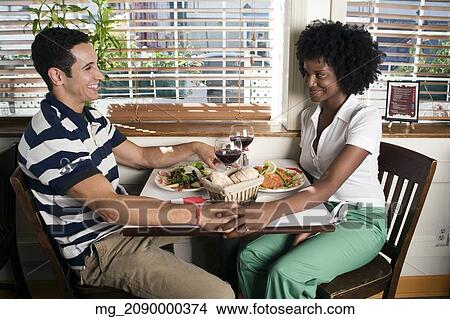 Picture - A young couple in their 20's enjoy a meal together in a restaurant. September 1, 2006. © RD / Retna Digital. Fotosearch