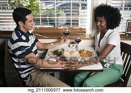 A young couple in their 20's enjoy a meal together in a restaurant. September 1, 2006. © RD / Retna Digital View Large Photo Image Stock Photo - A young couple in their 20's enjoy a meal together in a restaurant. September 1, 2006. © RD / Retna Digital. Fotosearch