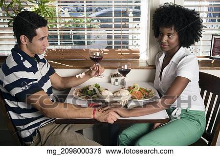A young couple in their 20's enjoy a meal together in a restaurant. September 1, 2006. © RD / Retna Digital View Large Photo Image Stock Photograph - A young couple in their 20's enjoy a meal together in a restaurant. September 1, 2006. © RD / Retna Digital. Fotosearch