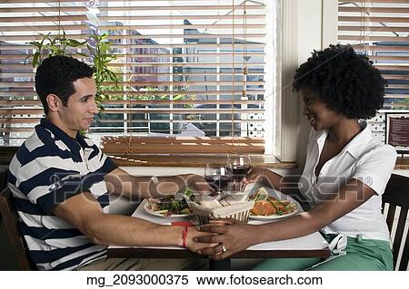 Stock Photography - A young couple in their 20's enjoy a meal together in a restaurant. September 1, 2006. © RD / Retna Digital. Fotosearch
