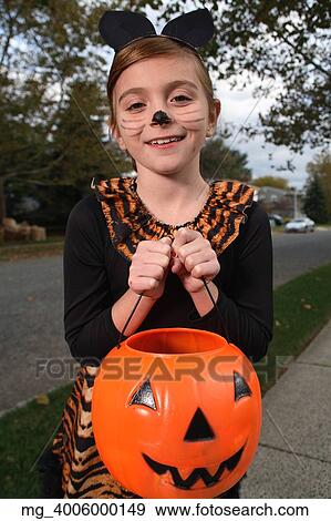 A young girl on the sidewalk on the quest for more halloween candy. She is dressed as a cat in a black unitard and tights with a animal print fur trim collar and skirt. She uses makeup to a cat noses and whiskers and costume ears. She is holding a pump View Large Photo Image Stock Photo - A young girl on the sidewalk on the quest for more halloween candy. She is dressed as a cat in a black unitard and tights with a animal print fur trim collar and skirt. She uses makeup to a cat noses and whiskers and costume ears. She is holding a pump. Fotosearch