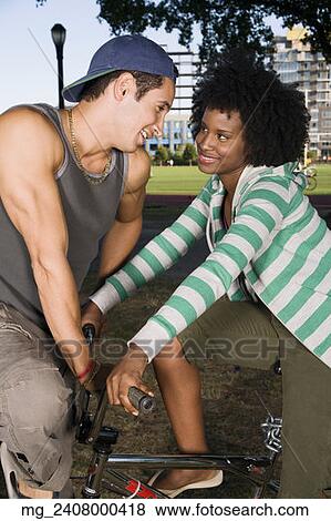 A young man and a young woman on a bike both in their 20's meet in the park and talk. September 1, 2006 credit - RD / Retna Digital View Large Photo Image Stock Photo - A young man and a young woman on a bike both in their 20's meet in the park and talk. September 1, 2006 credit - RD / Retna Digital. Fotosearch