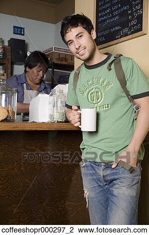 A young man wearing a backpack buys a drink from a coffee shop. December 30, 2006 credit - RD / Retna Digital View Large Photo Image Stock Image - A young man wearing a backpack buys a drink from a coffee shop. December 30, 2006 credit - RD / Retna Digital. Fotosearch