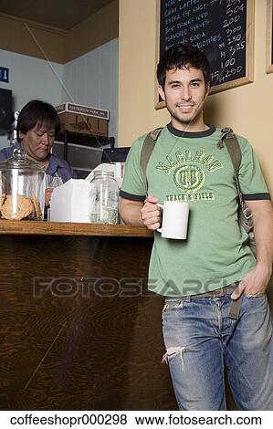 Stock Photo - A young man wearing a backpack buys a drink from a coffee shop. December 30, 2006 credit - RD / Retna Digital. Fotosearch