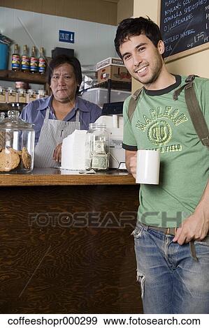 Stock Photo - A young man wearing a backpack buys a drink from a coffee shop. December 30, 2006 credit - RD / Retna Digital. Fotosearch