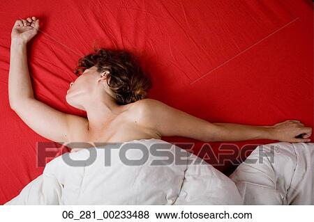 Above view head and shoulders woman waking up turning her head and stretching her arms from under a duvet View Large Photo Image Stock Photo - Above view head and shoulders woman waking up turning her head and stretching her arms from under a duvet. Fotosearch