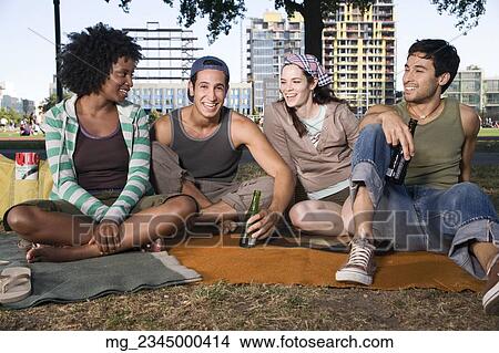Four friends in their 20's relax while and eating a snack in the park. September 1, 2006 credit - RD / Retna Digital View Large Photo Image Picture - Four friends in their 20's relax while and eating a snack in the park. September 1, 2006 credit - RD / Retna Digital. Fotosearch