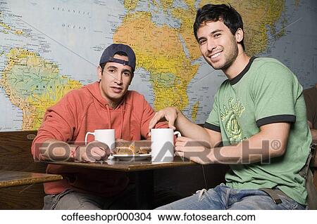 Picture - Two friends enjoy a drink at a coffee shop. December 30, 2006 credit - RD / Retna Digital. Fotosearch