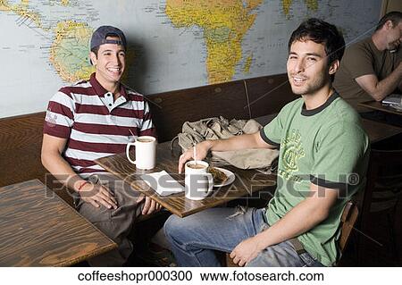 Stock Image - Two friends enjoy a drink at a coffee shop. December 30, 2006 credit - RD / Retna Digital. Fotosearch