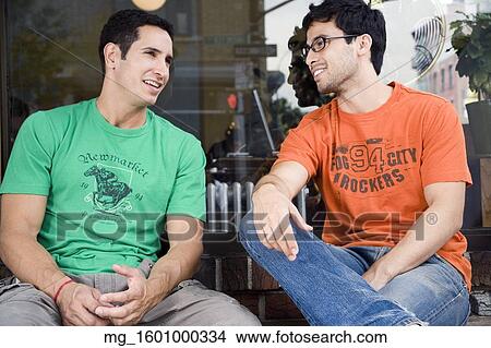 Picture - Two young men hang talk infront of a shop while enjoying a drink. September 1, 2006 credit - RD / Retna Digital. Fotosearch
