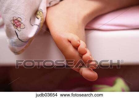 Picture - girl, Kind, child, bed, foot, close-up, indoor photo. Fotosearch