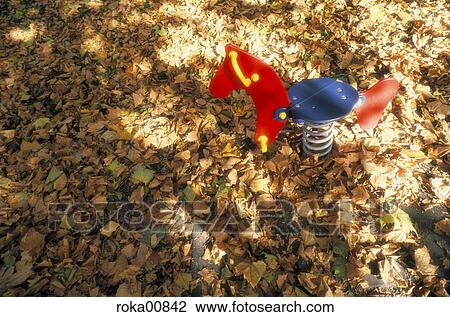 Stock Image - leaves, playground, fun, wooden horse, swing, foliage, autumn. Fotosearch