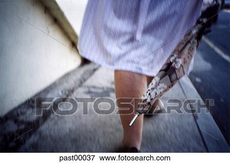 Stock Photo - legs, woman, old, umbrella, walking, sidewalk, lower leg. Fotosearch