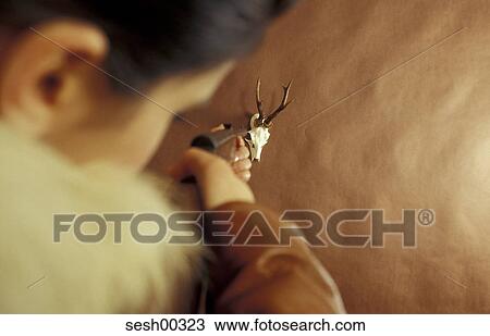 Stock Image - woman, in the back, fur, aim, back view, head, gun. Fotosearch