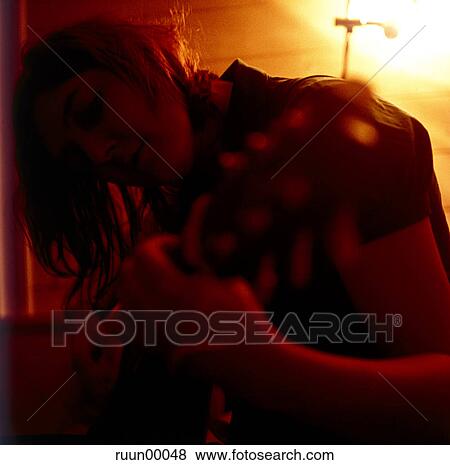 Stock Photo - woman, musician, guitar, play, evening, redly, red. Fotosearch