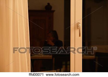 Stock Image - woman, smoke, smokes, hidden, window, windows, reflection. Fotosearch
