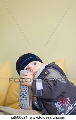 Stock Image - baby, blue eyes, child, big eyes, remote control, frontal, young. Fotosearch