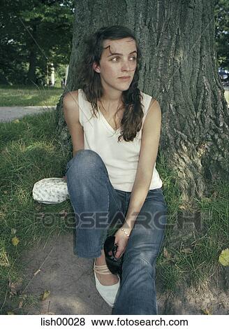 Stock Photo - brown hair, woman, grass, young woman, portrait, natural, outdoor shot. Fotosearch