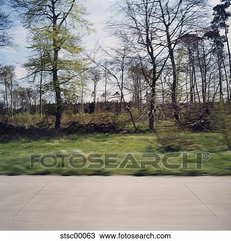 Stock Image - car, blue sky, motorway, Germany, blurred, speed, guardrail. Fotosearch