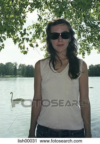 Stock Image - natural, brown hair, young woman, portrait, lake, outdoor shot, outside. Fotosearch