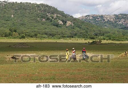 Stock Image - Women in Landscape Lake Kyle Zimbabwe. Fotosearch