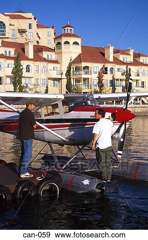 Stock Photo - Passenger and Pilot Examining Cessna Seaplane Canada. Fotosearch
