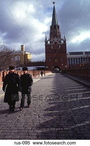 Stock Photography - Men Walking by Trinity Gate The Kremlin Moscow. Fotosearch