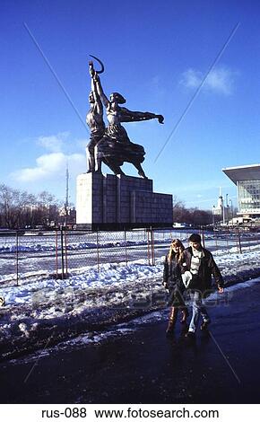 Stock Photo - Young Couple Walking by Collective Farmer Statue. Fotosearch