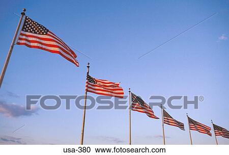 Stock Image - American Flags against Blue Sky Washington DC. Fotosearch