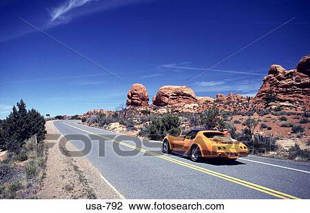 Stock Image - Sports Car on Highway Arches National Park Utah. Fotosearch
