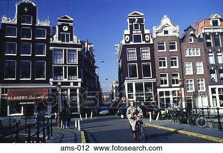 Cyclist on a Road through Gabled Houses Amsterdam View Large Photo Image Stock Image - Cyclist on a Road through Gabled Houses Amsterdam. Fotosearch