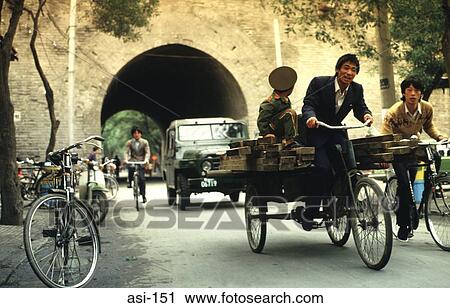 Stock Image - Man and Boy on Bicycle Cart on Busy Street China. Fotosearch