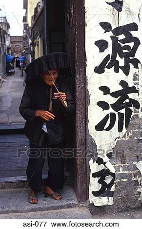 Stock Photo - Old Woman Smoking in Doorway Hong kong. Fotosearch