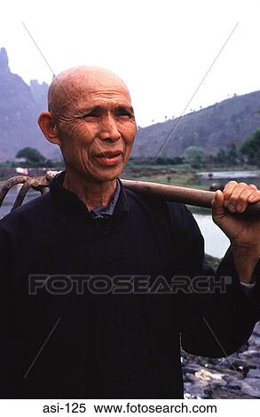 Stock Photography - Peasant Farmer Carrying Hoe Gulin China. Fotosearch