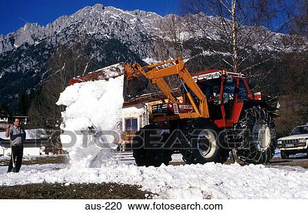 Stock Image - Tractor Clearing Snow in Rural Austria. Fotosearch
