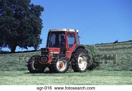 Tractor Reversing to Pick up a Circular Bail Of Hay View Large Photo Image Stock Photograph - Tractor Reversing to Pick up a Circular Bail Of Hay. Fotosearch
