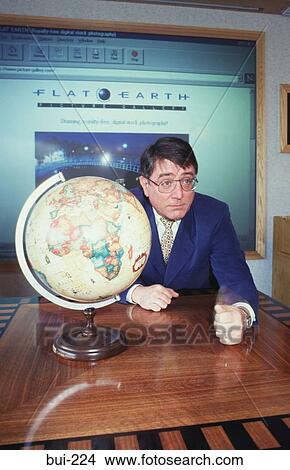 Businessman Sitting at Table with a Globe UK View Large Photo Image Picture - Businessman Sitting at Table with a Globe UK. Fotosearch