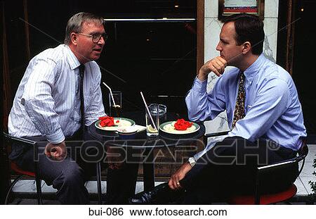 Stock Photograph - Businessmen Talking Over Cafe Table London. Fotosearch