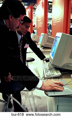 Businessmen Using Computers at Industry Fair View Large Photo Image Stock Photo - Businessmen Using Computers at Industry Fair. Fotosearch