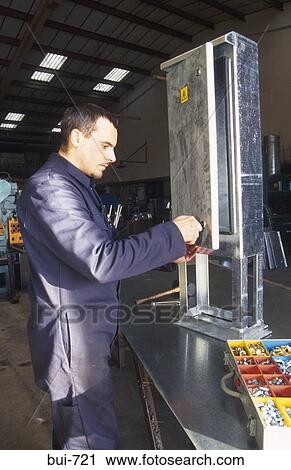 Stock Image - Engineer Assembling Control Cabinet UK. Fotosearch
