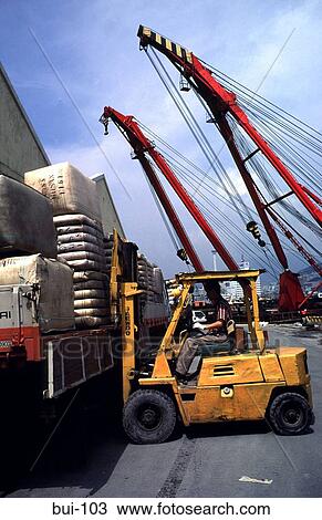 Stock Image - Fork Lift Truck loading at Quayside. Fotosearch