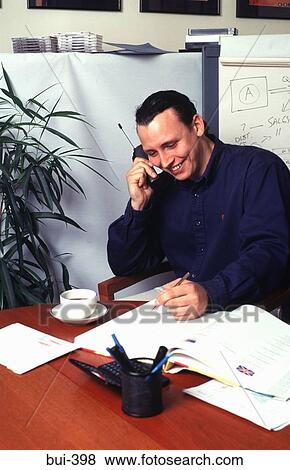 Man at Desk using Mobile Phone View Large Photo Image Stock Photo - Man at Desk using Mobile Phone. Fotosearch