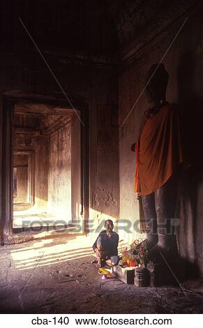 Stock Image - Man at Statue Angkor Wat Cambodia. Fotosearch