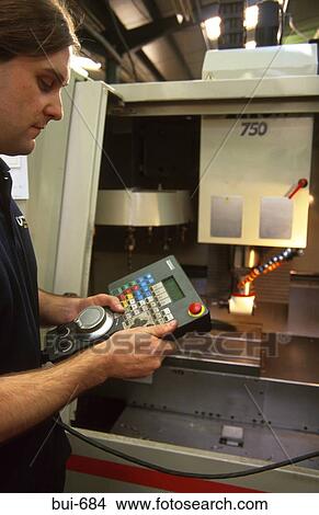 Picture - Man Using Machinery in Factory. Fotosearch