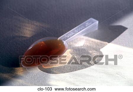 Stock Image - Medicine Spoon with Brown Syrup. Fotosearch