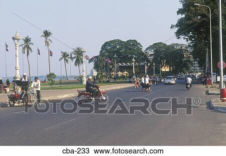 Stock Image - Motorbikes and Rickshaws Phnom Penh Cambodia. Fotosearch