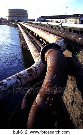 Stock Image - Rusty Piping Along River Bank. Fotosearch