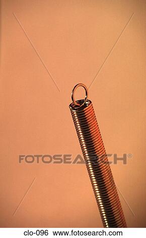 Tightly Coiled Spring on a Yellow Background View Large Photo Image Stock Photograph - Tightly Coiled Spring on a Yellow Background. Fotosearch